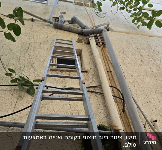 סולם וצינורות חיצוניים על קיר בניין